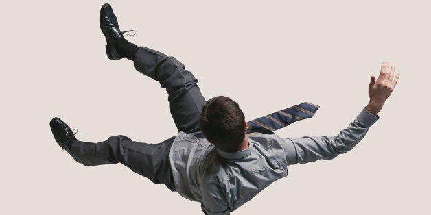 People captured in mid air, while jumping on trampoline in big studio.