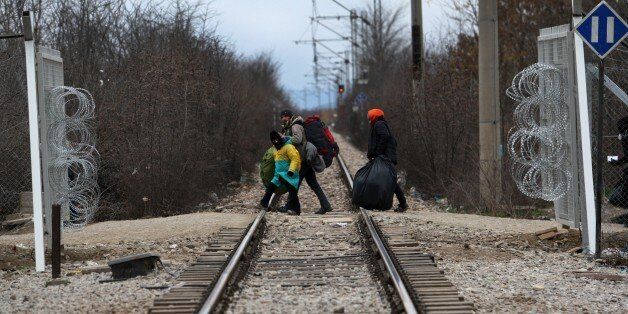 Migrants and refugees cross the Greek Macedonian border near the village of Idomeni, on February 5, 2016....