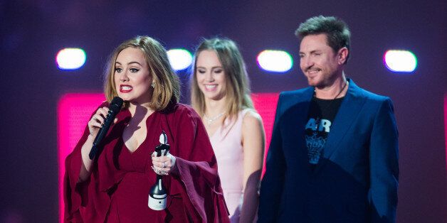 LONDON, ENGLAND - FEBRUARY 24: Adele accepts her British Single from Suki Waterhouse and Simon Le Bon at the BRIT Awards 2016 at The O2 Arena on February 24, 2016 in London, England. (Photo by Samir Hussein/Redferns)