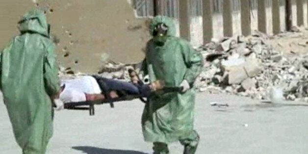 FILE - This image made from an AP video posted on Wednesday, Sept. 18, 2013 shows shows Syrians in protective suits and gas masks conducting a drill on how to treat casualties of a chemical weapons attack in Aleppo, Syria. The Islamic State group is aggressively pursuing development of chemical weapons, setting up a branch dedicated to research and experiments with the help of scientists from Iraq, Syria and elsewhere in the region, according to Iraqi and U.S. intelligence officials. (AP Photo via AP video, File)