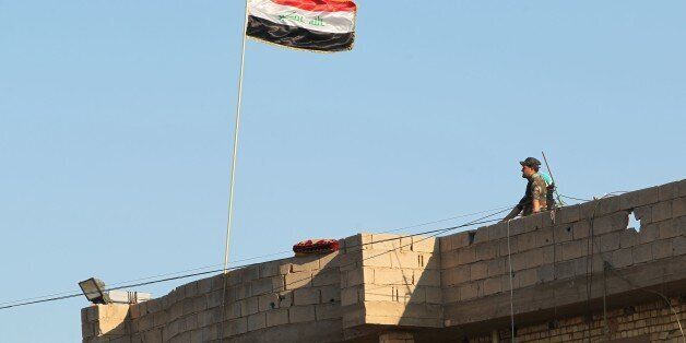 A member of Iraqi security forces stands on a roof on February 12, 2016, after security forces retook the eastern outskirts of Ramadi city from Islamic State (IS) group jihadists.Government forces recaptured areas on the eastern outskirts of the Anbar provincial capital from IS after weeks of fighting, and authorities say that all areas immediately surrounding the city have been retaken. / AFP / AHMAD AL-RUBAYE (Photo credit should read AHMAD AL-RUBAYE/AFP/Getty Images)