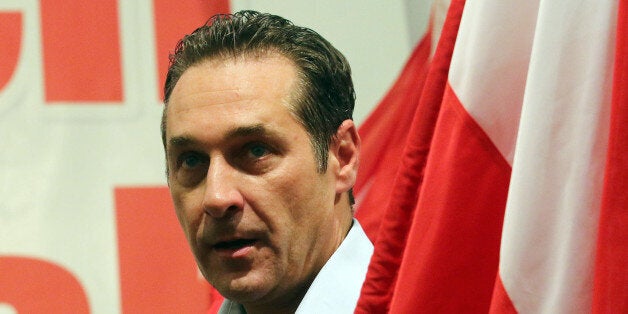 In this picture taken May 1, 2014, Heinz-Christian Strache head of Austria's right-wing Freedom Party, FPOE, arrives with a flag for a pre-election party for the European Parliament and May day celebrations at a beer tent in Linz, Austria. (AP Photo/Ronald Zak)