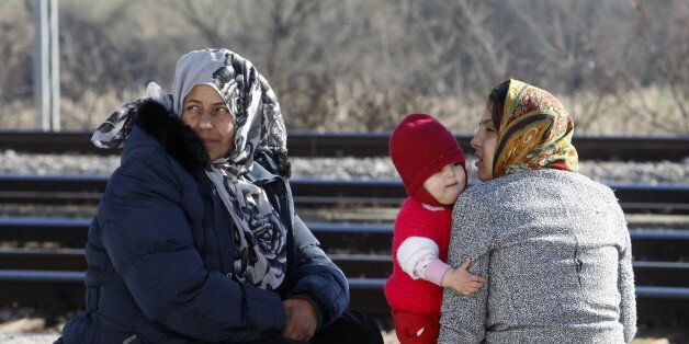Afghan refugee women with a baby, rest on a blanket at the transit center for refugees near the northern Macedonian village of Tabanovce, while waiting for a permission to cross the border into Serbia, Monday, Feb. 22, 2016. Hundreds of Afghan refugees were stranded since Saturday at the transit center in Tabanovce in northern Macedonia. Serbia says the decision to block refugees from Afghanistan from passing through the so-called Balkan migrant corridor has been made by Austria and Slovenia. (AP Photo/Boris Grdanoski)