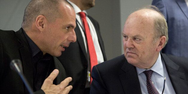 Greek Finance Minister Yanis Varoufakis, left, speaks with Irish Finance Minister Michael Noonan at the start of the annual meeting of the European Stability Mechanism Board in Luxembourg on Thursday, June 18, 2015. German Chancellor Angela Merkel is pressing Greece to deliver on commitments to carry out reforms, stressing that she wants the country to remain in the common currency. (AP Photo/Virginia Mayo)