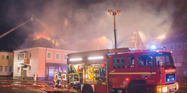 Fire fighters try to extinguish a fire at a former hotel that was under reconstruction to become a home for asylum seekers on February 21, 2016 in Bautzen east of Dresden, eastern Germany.According to the police, the fire broke out for still unknown reasons during the night to Sunday (February 21, 2016). Nobody was injured, as the shelter was not yet inhabited. Onlookers commented the fire with derogatory remarks on refugees. / AFP / dpa / Rico Loeb / Germany OUT (Photo credit should read RICO LOEB/AFP/Getty Images)