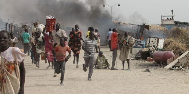 TOPSHOT - South Sudanese civilians flee fighting in an United Nations base in the northeastern town of Malakal on February 18, 2016, where gunmen opened fire on civilians sheltering inside killing at least five people.Gunfire broke out in the base in Malakal in the northeast Upper Nile region on February 17, 2016 night, with clashes continuing on Thursday morning that left large plumes of smoke rising from burning tents in the camp which houses over 47,000 civilians. / AFP / Justin LYNCH (Photo credit should read JUSTIN LYNCH/AFP/Getty Images)