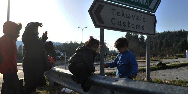 Children play as refugees and migrants walk to cross the Greek-Macedonian border near the village of Idomeni, northern Greece, on February 23, 2016. Greece said on February 22 that it was taking action to persuade Macedonia to take in Afghan migrants as thousands remained stranded at the border and the main port in Athens. About 5,000 refugees and migrants are stuck at the border with Macedonia after the neighbouring non-EU state on February 21 refused to allow passage to Afghans, police said. / AFP / SAKIS MITROLIDIS (Photo credit should read SAKIS MITROLIDIS/AFP/Getty Images)