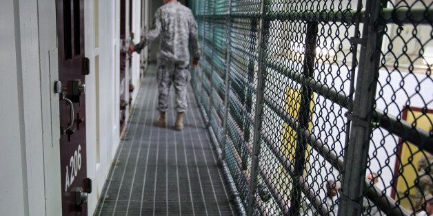 In this Feb. 6, 2016 photo, an Army captain walks outside unoccupied detainee cells inside Camp 6 at the U.S. detention center at Guantanamo Bay, Cuba. (AP Photo/Ben Fox)