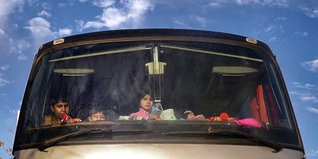 ATHENS, GREECE - FEBRUARY 18: Migrant children look from the window of a bus in Pireaus, port of Athens on Februray 18, 2016 in Athens, Greece. Migrants continue to pour into Greece as EU leaders meet in Brussels for a two day summit. Greece is under pressure from the EU to improve conditions for migrants. More than one million migrants entered Europe in 2015, whilst another 3500 died in the process. (Photo by Milos Bicanski/Getty Images)