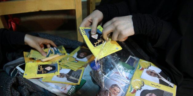An election campaign worker makes packages of leaflets of a group of conservative candidates in the upcoming parliamentary elections during a gathering in Tehran, Iran, Monday, Feb. 22, 2016. Iranians will vote for their representatives at the 290-seat parliament, as two major camps of conservatives and a coalition of reformists and moderates compete to win the majority of the house. On the same day as the parliamentary elections, polling for the Assembly of Experts, a 88-member clerical body in charge of selecting the countryâs supreme leader, will take place. (AP Photo/Vahid Salemi)