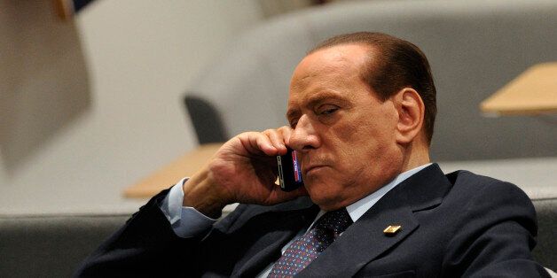 ItalianPrime Minister Silvio Berlusconi phones prior to an European Council at the Justus Lipsius building, EU headquarters in Brussels on October 23, 2011. Europe aimed to nail down a solution to the worst economic crisis in its history, as the spotlight at an emergency meeting of EU leaders fell on Italy amid contagion fears in the eurozone. The two key players, Germany Chancellor Angela Merkel and French President Nicolas Sarkozy, hailed 'progress' in fighting the crisis as finance ministers thrashed out a framework to protect banks after a marathon session of talks. AFP PHOTO/ ERIC FEFERBERG (Photo credit should read ERIC FEFERBERG/AFP/Getty Images)