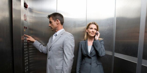 Two business people in elevator