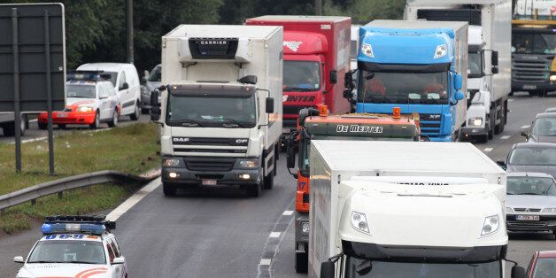 Trucks drive in a slow convoy on the Brussels ring road, as they participate in a demonstration, Monday Sept. 24, 2012. Truckers seek to disrupt morning traffic heading into the capital to protest competition from eastern Europe, which undercuts prices and lowers labor standards. (AP Photo/Yves Logghe)