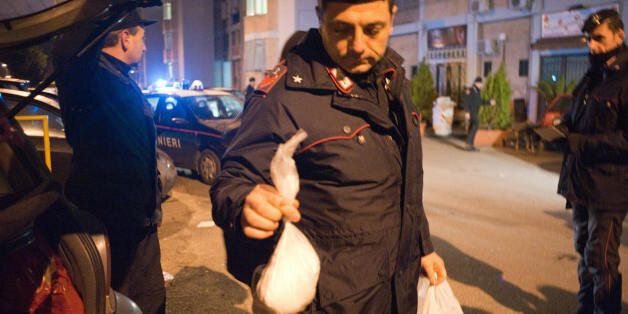 An Italian policeman holds a bag full of cocaine which was found in a car in the Scampia area of Naples early on February 10, 2009. 35 arrest warrants were issued in several areas of Italy with 29 people arrested during the operation against a cartel importing drug from Spain. AFP PHOTO / FRANCESCO PISCHETOLA (Photo credit should read FRANCESCO PISCHETOLA/AFP/Getty Images)