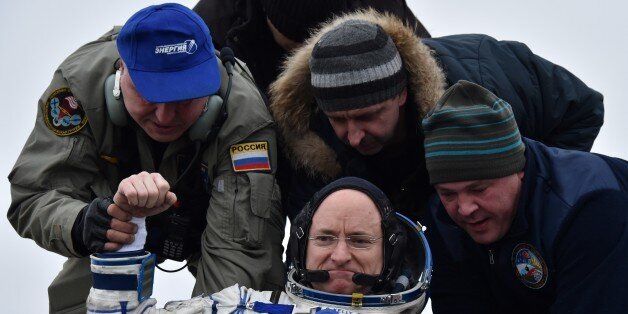 Ground personnel help International Space Station (ISS) crew member Scott Kelly of the U.S. to get off the Soyuz TMA-18M space capsule after landing near the town of Dzhezkazgan, Kazakhstan, on March 2, 2016. US astronaut Scott Kelly and Russian cosmonaut Mikhail Kornienko returned to Earth on March 2 after spending almost a year in space in a ground-breaking experiment foreshadowing a potential manned mission to Mars. AFP PHOTO / POOL / KIRILL KUDRYAVTSEV / AFP / POOL / KIRILL KUDRYAVTSEV (Photo credit should read KIRILL KUDRYAVTSEV/AFP/Getty Images)