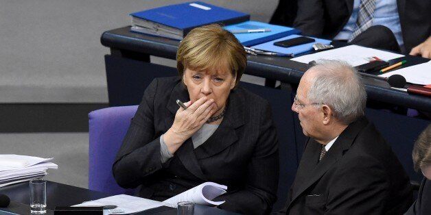 German Chancellor Angela Merkel (L) chats with German Finance Minister Wolfgang Schaeuble during a plenary session of the German lower house of parliament Bundestag before deputies vote on a stepped-up German role in the fight against the Islamic State group in Berlin December 4, 2015. The mandate would cover six Tornado reconnaissance jets, one refuelling aircraft, a naval frigate and up to 1,200 troops following a request from France after the November 13 jihadist attacks. AFP PHOTO / TOBIAS SCHWARZ / AFP / TOBIAS SCHWARZ (Photo credit should read TOBIAS SCHWARZ/AFP/Getty Images)
