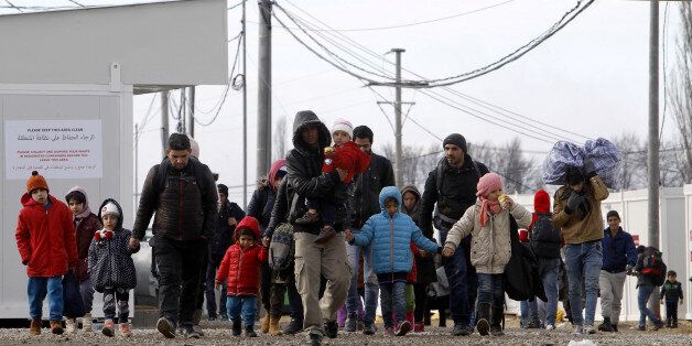 Refugees with children walk towards the border with Serbia from the transit center for refugees near northern Macedonian village of Tabanovce, Friday, Feb. 12, 2016. In a dramatic response to Europe's gravest refugee crisis since World War II, NATO ordered three warships to sail immediately Thursday to the Aegean Sea to help end the deadly smuggling of asylum-seekers across the waters from Turkey to Greece. (AP Photo/Boris Grdanoski)