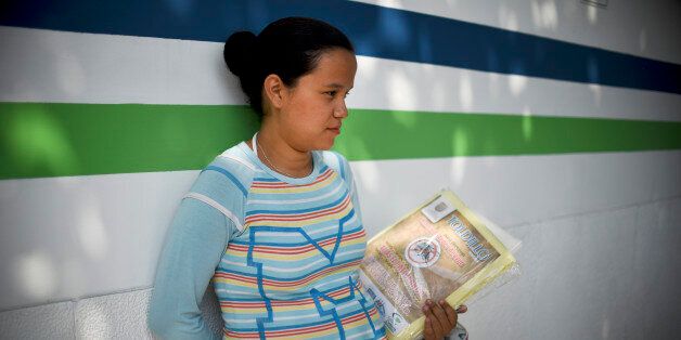 A pregnant woman holds a mosquito net in Cali on February 10, 2016. The Colombian Health Ministry began delivering mosquito nets for free to pregnant women to prevent the infection by Zika virus, vectored by the Aedes aegypti mosquito. The World Health Organization on Tuesday urged caution about linking the Zika virus with a rare nerve disorder called Guillain-Barre which health officials in Colombia have blamed for three deaths. AFP PHOTO / LUIS ROBAYO / AFP / LUIS ROBAYO (Photo credit