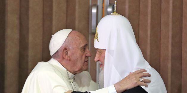 Pope Francis (L) and the head of the Russian Orthodox Church, Patriarch Kirill (R), approach to kiss before delivering a joint press conference during a historic meeting in Havana on February 12, 2016. Pope Francis and Russian Orthodox Patriarch Kirill kissed each other and sat down together Friday at Havana airport for the first meeting between their two branches of the church in nearly a thousand years. AFP PHOTO / POOL - Alejandro Ernesto / AFP / POOL / ALEJANDRO ERNESTO (Photo credit