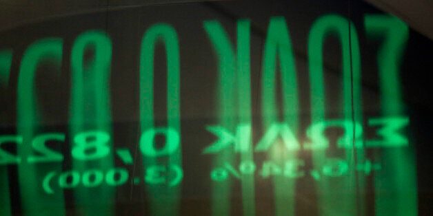 A reflection of share prices on an electronic ticker screen sits on a glass door panel inside the Athens Stock Exchange on Wednesday, Aug. 5, 2015. Greece's government aims to reach agreement with creditors on a new bailout within the next two weeks, enabling it to make a 3.2 billion-euro ($3.5 billion) payment to the European Central Bank without further bridge financing. Photographer: Kostas Tsironis/Bloomberg via Getty Images