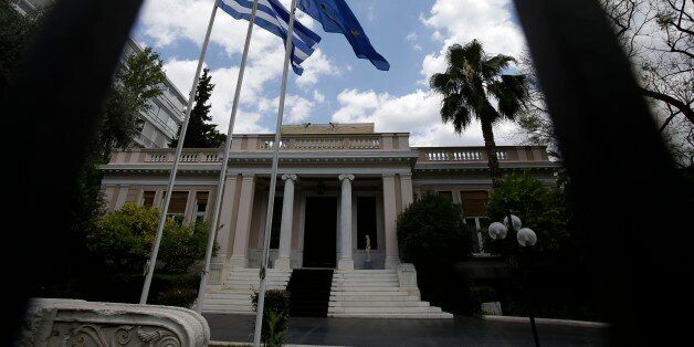 The flags of Greece and European Union flutter outside Maximos Mansion, Prime Minister's office, in Athens on Tuesday, June 23, 2015. The country this week offered a series of measures, including multiple tax increases, to persuade its creditors to release bailout funds and keep the country from defaulting on its debts as soon as next week. (AP Photo/Thanassis Stavrakis)