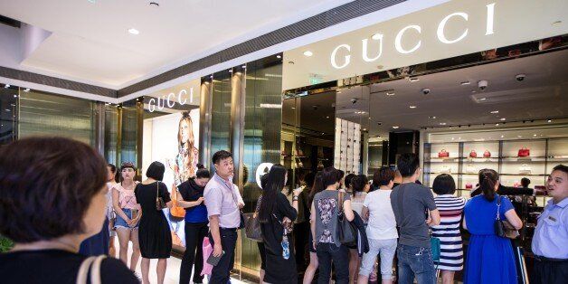 HANGZHOU, CHINA - MAY 27: (CHINA OUT) Customers wait outside Gucci Store in Hangzhou Tower Shopping City to enjoy Gucci's 50% discount on May 27, 2015 in Hangzhou, Zhejiang province of China. It was said that luxuries as Chanel, Cartier had cut price in China before and Gucci had also reduced their price of most articles with fifty percent discount in China on May 27. (Photo by ChinaFotoPress/ChinaFotoPress via Getty Images)