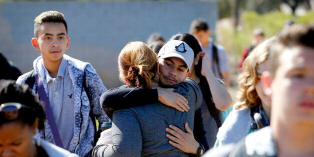 Parents and students reunite, Friday, Feb. 12, 2016, in Glendale, Ariz. after two teens were shot Friday at Independence High School in the Phoenix suburb. Two 15-year-old girls were shot once at the school, but it was not clear what led up to their deaths, Glendale Officer Tracey Breeden told reporters. Authorities were not looking for anyone else, and a gun was found near the bodies, she said. (AP Photo/Matt York)