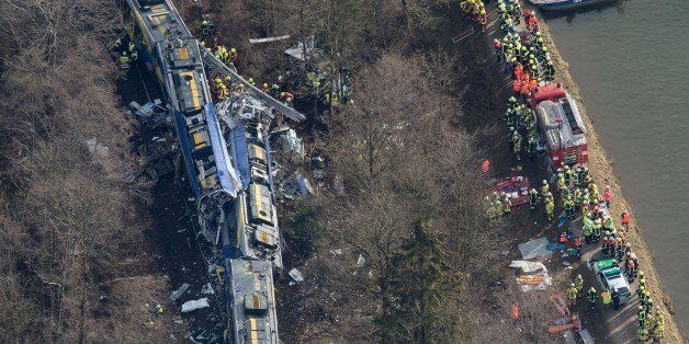 Aerial view shows firefighters and emergency doctors working at the site of a train accident near Bad Aibling, southern Germany, on February 9, 2016.Two Meridian commuter trains operated by Transdev collided head-on near Bad Aibling, around 60 kilometres (40 miles) southeast of Munich, killing at least eight people and injuring around 100, police said. The cause of the accident was not immediately clear. / AFP / dpa / Peter Kneffel / Germany OUT (Photo credit should read PETER KNEFFEL/AFP