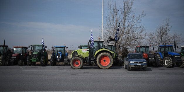 Tractors are parked alongside a motorway at the toll stations of Malgara village, near the northern Greek city of Thessaloniki, Sunday, Jan. 31, 2016. Greek farmers continued highway blockades as a range of other professions are on strike to protest planned pension reforms that are part of the country's third international bailout requirements. (AP Photo/Giannis Papanikos)