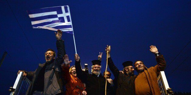 Farmers and priests stand on their tractors and vehicles as they arrive in front of the Greek parliament in Athens during a rally against pension reform, on February 12, 2016.Fears that Greece will exit the eurozone, a 'Grexit', could revive if Greek authorities do not come up with 'credible' reforms, notably on pensions, a senior IMF official said February 11. / AFP / LOUISA GOULIAMAKI (Photo credit should read LOUISA GOULIAMAKI/AFP/Getty Images)