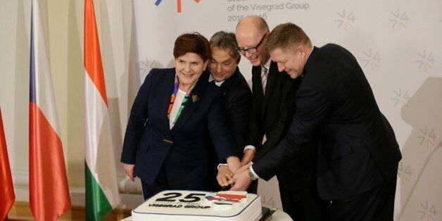 Prime Ministers of Czech Republic Bohuslav Sobotka, 2nd right, Poland Beata Szydlo, left, Hungary Viktor Orban, 2nd left, and Slovakia Robert Fico, right, join hands to cut a cake to celebrate 25th anniversary of the establishment of the Visegrad group prior a Summit of the V4 Prime Ministers with Prime Minister of Bulgaria and the President of Macedonia in Prague, Czech Republic, Monday, Feb. 15, 2016. (AP Photo/Petr David Josek)