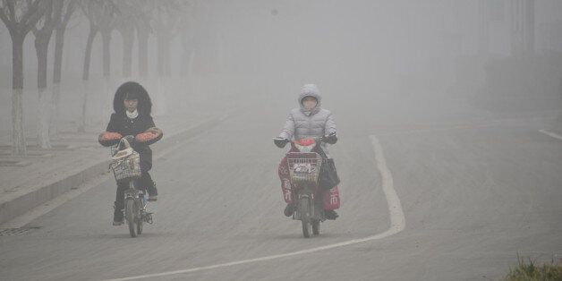 LIAOCHENG, CHINA - FEBRUARY 12: (CHINA OUT) Citizens ride in the heavy smog on February 12, 2015 in Liaocheng, Shandong Province of China. Chinese people exploded firecrackers during the lunar new year holiday which made the air quality bad in some parts of China. (Photo by ChinaFotoPress/ChinaFotoPress via Getty Images)