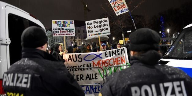 Police keeping the two sides apart watch protestors opposing the PEGIDA movement (Patriotic Europeans Against the Islamisation of the Occident) attend a counter rally in Leipzig on January 11, 2016.The counter demonstrators lit torches and shouted slogans as supporters of the xenophobic far-right movement PEGIDA gathered to mark the first year of the local chapter LEGIDA, as public anger runs high over the Cologne assaults. / AFP / TOBIAS SCHWARZ (Photo credit should read TOBIAS SCHWARZ/AFP/Getty Images)