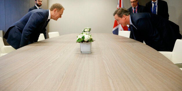 British Prime Minister David Cameron, right, takes his seat with European Council President Donald Tusk, left, during a bilateral meeting on the sidelines of an EU summit in Brussels on Thursday, Feb. 18, 2016. European Union leaders are holding a summit in Brussels on Thursday and Friday to hammer out a deal designed to keep Britain in the 28-nation bloc. (Olivier Hoslet, Pool Photo via AP)