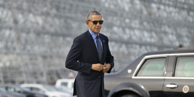President Barack Obama adjust his suit jacket as he walks across the tarmac before boarding Air Force One at Moffett Federal Airfield in Mountain View, Calif., Thursday, Feb. 11, 2016. Obama is traveling to Los Angeles to tape an appearance on the Ellen DeGeneres Show and attend a pair of private Democratic fundraisers later today. (AP Photo/Pablo Martinez Monsivais)
