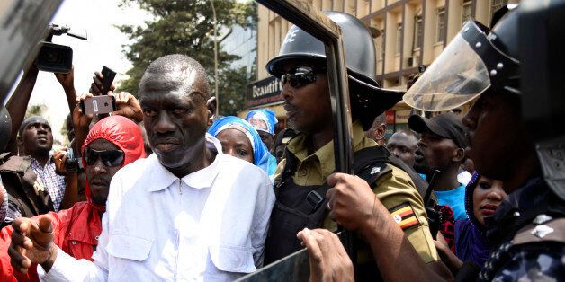 Uganda Anti-riot police officers arrest opposition leader, Kizza Besigye as he was walking on a busy Kampala street with his supporters moments after he was tear gassed by Ugandan riot police on February 15, 2016. Besigye was today arrested by Uganda police and taken to unknown police station. / AFP / ISAAC KASAMANI (Photo credit should read ISAAC KASAMANI/AFP/Getty Images)