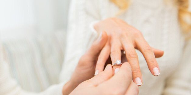 love, couple, relationship and holidays concept - close up of man giving diamond ring to woman