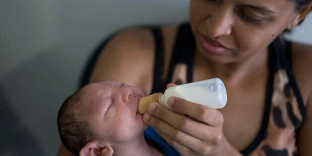 Daniele Ferreira dos Santos feeds her son Juan Pedro, who suffers from microcephaly, as they wait to be examined at the Altino Ventura Foundation, a treatment center that provides free health care, in Recife, Pernambuco state, Brazil, Thursday, Feb. 4, 2016. Brazil is in the midst of a Zika outbreak and authorities say they have also detected a spike in cases of microcephaly in newborn children, but the link between Zika and microcephaly is as yet unproven. (AP Photo/Felipe Dana)