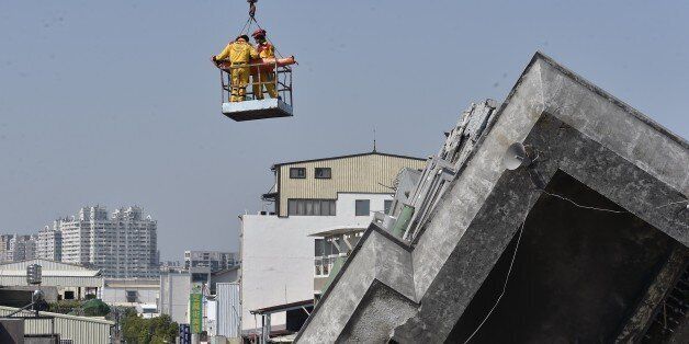 A 40-year-old man, identified by local media as Lee Tsung-tian, is lifted by a crane out of the rubble by rescue workers at the Wei-Kuan complex which collapsed in the 6.4 magnitude earthquake, in the southern Taiwanese city of Tainan on February 8, 2016. Two survivors were on February 8 rescued from the rubble of an apartment complex in Taiwan felled by an earthquake, after being trapped for more than 50 hours. AFP PHOTO / Sam Yeh / AFP / SAM YEH (Photo credit should read SAM YEH/A