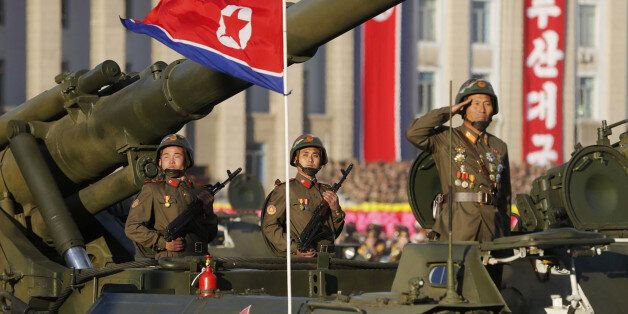 PYONGYANG, NORTH KOREA - OCTOBER 10: (CHINA OUT) Soldiers hold their weapons as they ride on a tank during the parade at Kim Il-Sung square to mark the 70th anniversary of its ruling Worker's Party of Korea on October 10, 2015 in Pyongyang, North Korea. (Photo by Liu Xingzhe/ChinaFotoPress via Getty Images)
