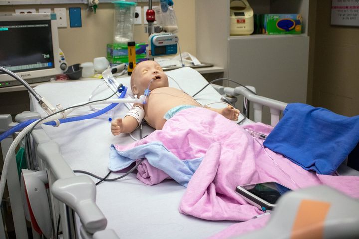 A baby mannequin used for training lies in a pediatric ICU bed at SickKids in Toronto. The baby can breathe and blink and is highly realistic.