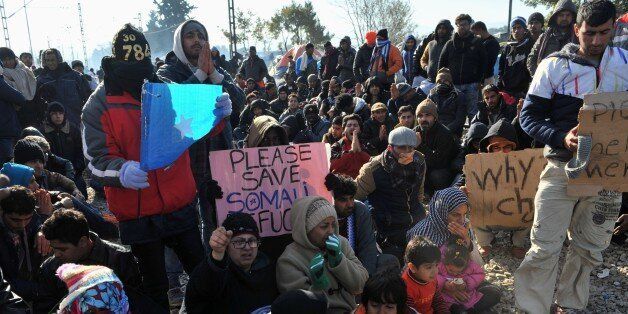 Migrants and refugees hold placards as they protest while waiting to cross the Greek-Macedonian border near Idomeni on December 7, 2015.Macedonia has restricted passage to northern Europe to only Syrians, Iraqis and Afghans who are considered war refugees. All other nationalities are deemed economic migrants and told to turn back, leaving over 1,500 people stuck on the border. / AFP / SAKIS MITROLIDIS (Photo credit should read SAKIS MITROLIDIS/AFP/Getty Images)