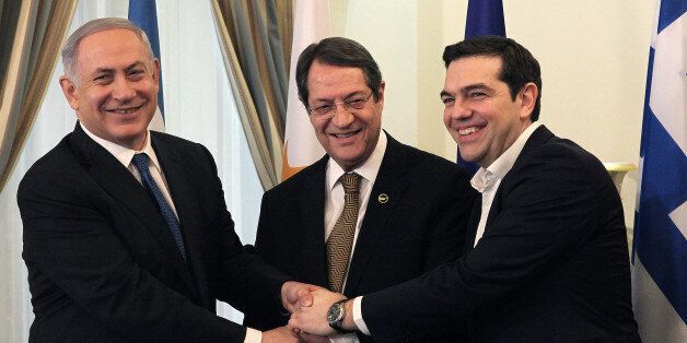 Cypriot president Nicos Anastasides, center, Greek Prime Minister Alexis Tsipras, right, and Israeli Prime Minister Benjamin Netanyahu shake hands during their meeting at the presidential palace in capital Nicosia in the mediterranean island of Cyprus, Thursday, Jan. 28, 2016. The leaders of Cyprus, Greece and Israel are meeting in the Cypriot capital with the aim to strengthen cooperation and bolster stability in a region wracked by conflict. Discussions will cover newly found offshore gas reserves and tourism, while the leaders will sign a cooperation agreement on water resources. (Yiannis Kourtoglou, Pool Photo via AP)
