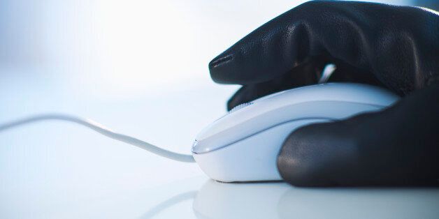 A gloved hand on a computer mouse