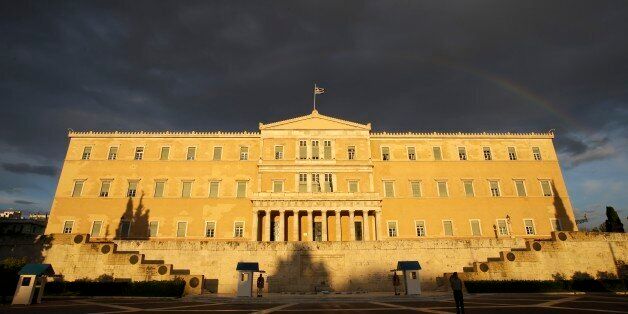 Presidential guards stand at the tomb of the unknown soldier in front of Greece's Parliament as a rainbow appears after a rainfall in Athens on Monday, May 5, 2014. Greece will achieve better-than-expected budget figures in 2014 but unemployment will only decline slowly over the next four years, the country's finance ministry said last week. (AP Photo/Thanassis Stavrakis)
