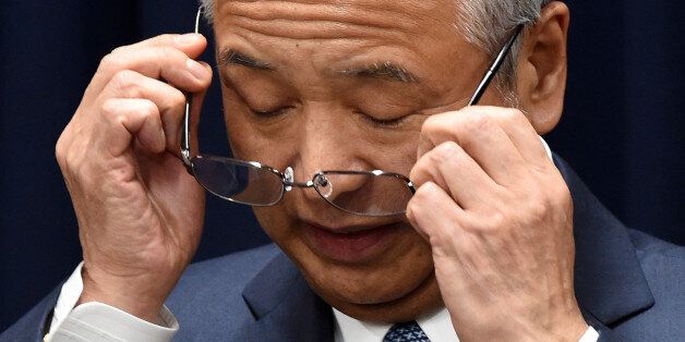Japan's Economy Minister Akira Amari puts on his glasses during a press conference in Tokyo on January 28, 2016. Amari stepped down over graft allegations, in a blow to Prime Minister Shinzo Abe ahead of a key leadership vote this year. AFP PHOTO / Toru YAMANAKA / AFP / TORU YAMANAKA (Photo credit should read TORU YAMANAKA/AFP/Getty Images)