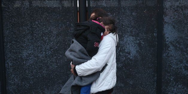PADBORG, DENMARK - JANUARY 06: A man from Syria carries his sleeping daughter as he walks to a police van after Danish police found them and other migrants while checking the identity papers of passengers on a train arriving from Germany on January 6, 2016 in Padborg, Denmark. Denmark introduced a 10-day period of passport controls and spot checks on Monday on its border to Germany in an effort to stem the arrival of refugees and migrants seeking to pass through Denmark on their way to Sweden.