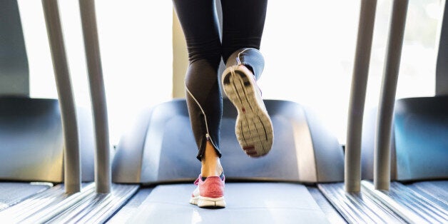 Low section of woman exercising on treadmill