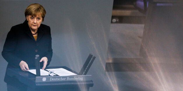 This photo taken with reflection on a metal handrail of the visitors tribune, German Chancellor Angela Merkel delivers her speech about the upcoming European Summit at the German parliament Bundestag in Berlin, Wednesday, Dec. 16, 2015. European leaders will meet in Brussels for a summit starting Thursday Dec. 17, 2015. (AP Photo/Markus Schreiber)