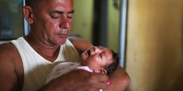 RECIFE, BRAZIL - JANUARY 27: Alice Vitoria Gomes Bezerra, 3-months-old, who has microcephaly, is held by her father Joao Batista Bezerra on January 27, 2016 in Recife, Brazil. In the last four months, authorities have recorded close to 4,000 cases in Brazil in which the mosquito-borne Zika virus may have led to microcephaly in infants. The ailment results in an abnormally small head in newborns and is associated with various disorders including decreased brain development. According to the World Health Organization (WHO), the Zika virus outbreak is likely to spread throughout nearly all the Americas. At least twelve cases in the United States have now been confirmed by the CDC. (Photo by Mario Tama/Getty Images)